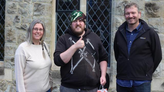 Ben giving a thumbs up next to two support workers