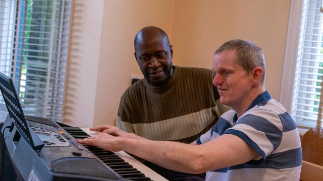 Paddy playing the piano with Tendekai
