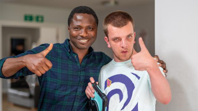 Jake and a support worker giving a thumbs up
