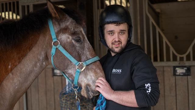 Charlie smiling with a horse at HorseWorld, a charity in Bristol