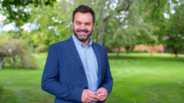 Paul Pargeter smiling at Hampton Court while wearing a blue blazer and shirt
