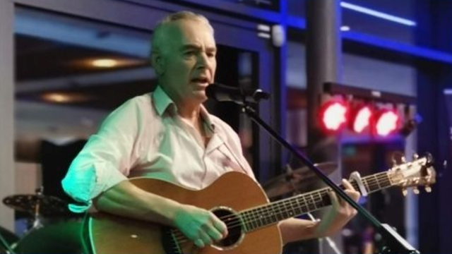 Nigel Waite playing guitar on stage